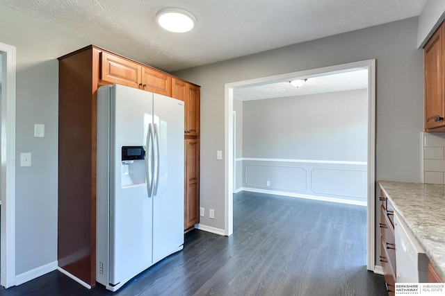 5023 N 96th St, Omaha, NE 68134 - kitchen with white fridge with ice dispenser, dark wood-style floors, brown cabinetry, and a textured ceiling