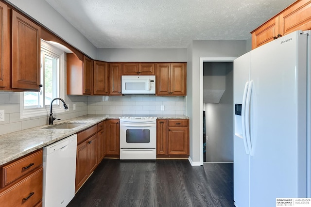 5023 N 96th St, Omaha, NE 68134 - kitchen featuring white appliances, dark wood-style flooring, brown cabinetry, tasteful backsplash, and a textured ceiling