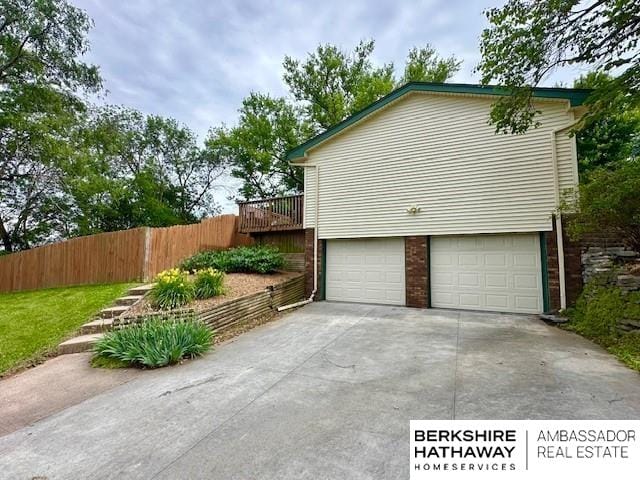 5023 N 96th St, Omaha, NE 68134 - view of home's exterior with concrete driveway, an attached garage, and brick siding