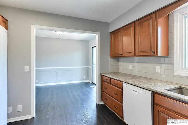 5023 N 96th St, Omaha, NE 68134 - kitchen featuring white dishwasher, brown cabinets, dark wood finished floors, backsplash, and light stone counters