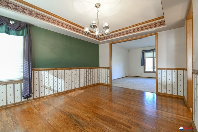 3646 S 77th St, Lincoln, NE 68506 - empty room featuring a chandelier, wood finished floors, a tray ceiling, ornamental molding, and wainscoting
