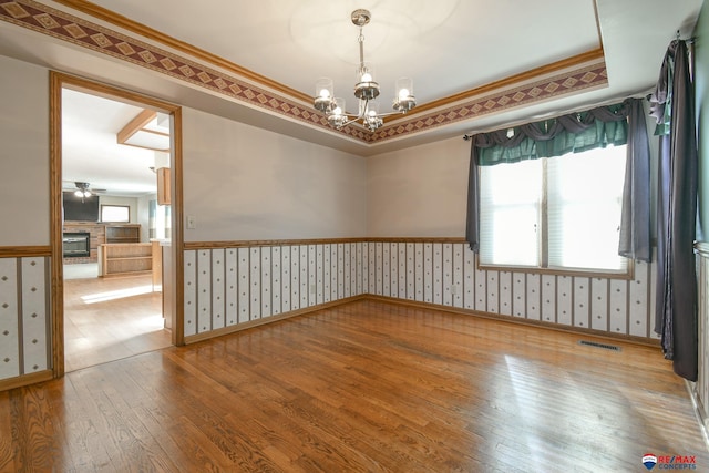 3646 S 77th St, Lincoln, NE 68506 - spare room featuring hardwood / wood-style floors, wallpapered walls, wainscoting, a chandelier, and a ceiling fan