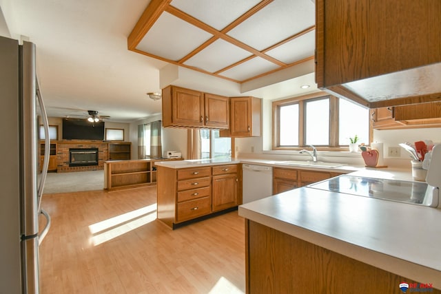 3646 S 77th St, Lincoln, NE 68506 - kitchen with white dishwasher, freestanding refrigerator, a fireplace, open floor plan, and a peninsula
