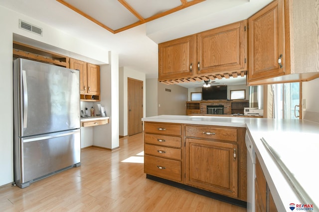 3646 S 77th St, Lincoln, NE 68506 - kitchen featuring freestanding refrigerator, light countertops, brown cabinetry, light wood-style flooring, and a peninsula