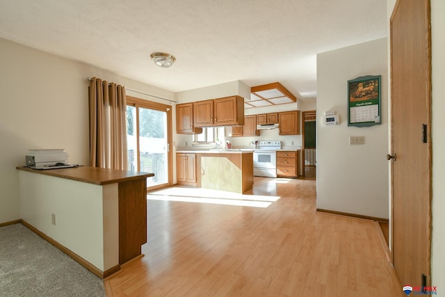 3646 S 77th St, Lincoln, NE 68506 - kitchen featuring white electric range, a peninsula, under cabinet range hood, light wood-style floors, and brown cabinetry