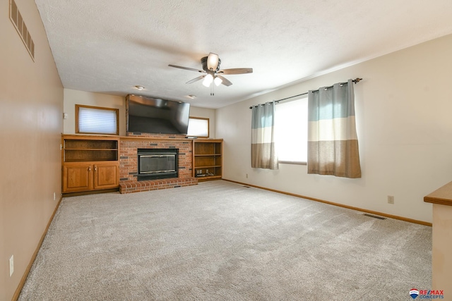 3646 S 77th St, Lincoln, NE 68506 - unfurnished living room with ceiling fan, light carpet, a brick fireplace, and a textured ceiling