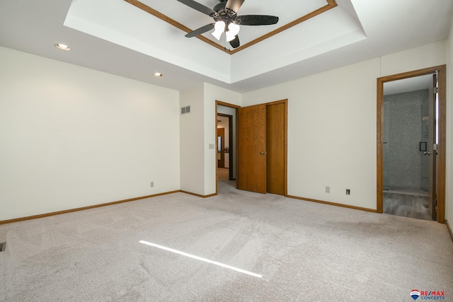 3646 S 77th St, Lincoln, NE 68506 - unfurnished bedroom featuring a tray ceiling, carpet floors, recessed lighting, ensuite bathroom, and a ceiling fan