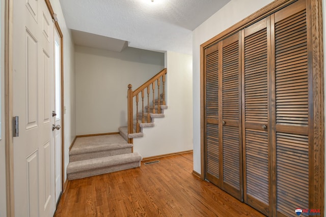 3646 S 77th St, Lincoln, NE 68506 - entrance foyer with stairway, wood finished floors, and a textured ceiling
