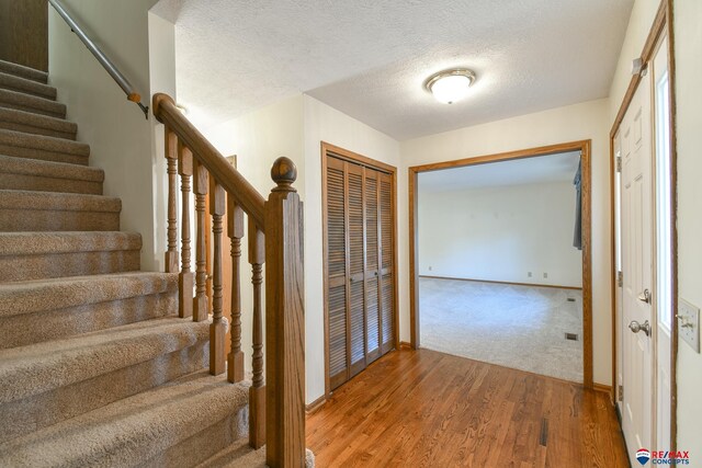 3646 S 77th St, Lincoln, NE 68506 - foyer featuring stairs, wood finished floors, and a textured ceiling