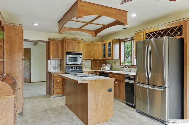 15618 L St, Omaha, NE 68135 - kitchen featuring appliances with stainless steel finishes, light countertops, brown cabinets, a kitchen island, and glass insert cabinets