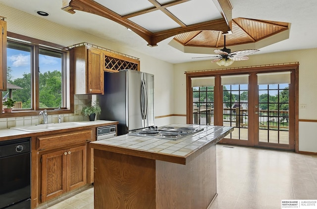 15618 L St, Omaha, NE 68135 - kitchen with tile counters, stainless steel appliances, plenty of natural light, and brown cabinets