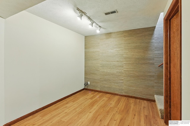 15618 L St, Omaha, NE 68135 - spare room with rail lighting, light wood finished floors, and a textured ceiling
