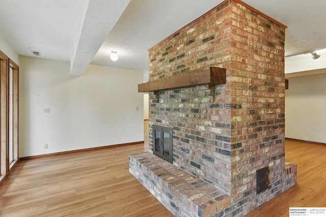 15618 L St, Omaha, NE 68135 - unfurnished living room featuring a brick fireplace and light wood-type flooring