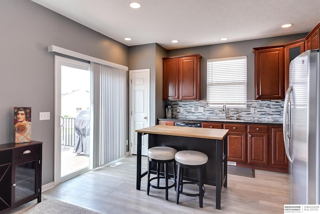 16501 Aurora St, Omaha, NE 68136 - kitchen featuring freestanding refrigerator, backsplash, a kitchen breakfast bar, butcher block counters, and light wood-type flooring