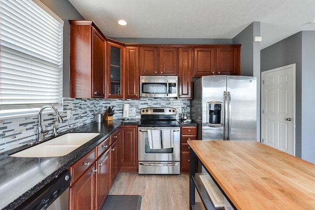 16501 Aurora St, Omaha, NE 68136 - kitchen with stainless steel appliances, wood counters, light wood-type flooring, tasteful backsplash, and glass insert cabinets