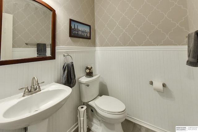 16501 Aurora St, Omaha, NE 68136 - bathroom featuring a wainscoted wall, wood finished floors, and wallpapered walls