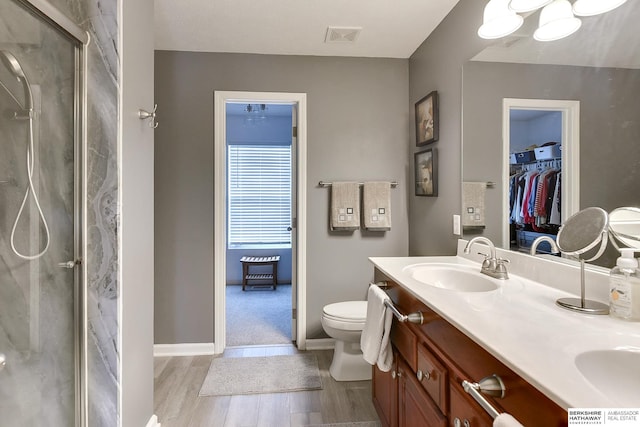 16501 Aurora St, Omaha, NE 68136 - full bathroom featuring wood finished floors, double vanity, a marble finish shower, and a walk in closet
