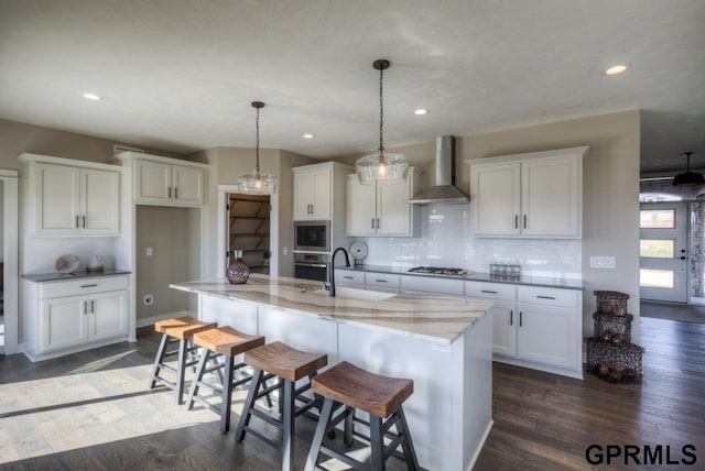 3103 N 184th St, Elkhorn, NE 68022 - kitchen featuring wall chimney exhaust hood, appliances with stainless steel finishes, white cabinetry, decorative backsplash, and light stone countertops