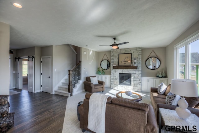 3103 N 184th St, Elkhorn, NE 68022 - living room featuring dark wood-type flooring, stairway, a barn door, a stone fireplace, and ceiling fan