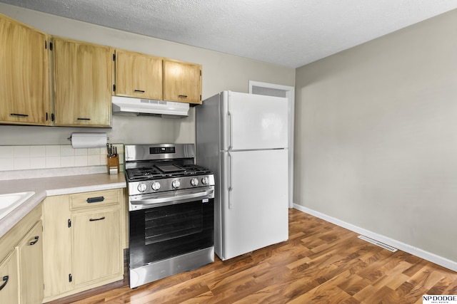 7348 S 71st Ave, La Vista, NE 68128 - kitchen with under cabinet range hood, gas stove, freestanding refrigerator, wood finished floors, and light countertops
