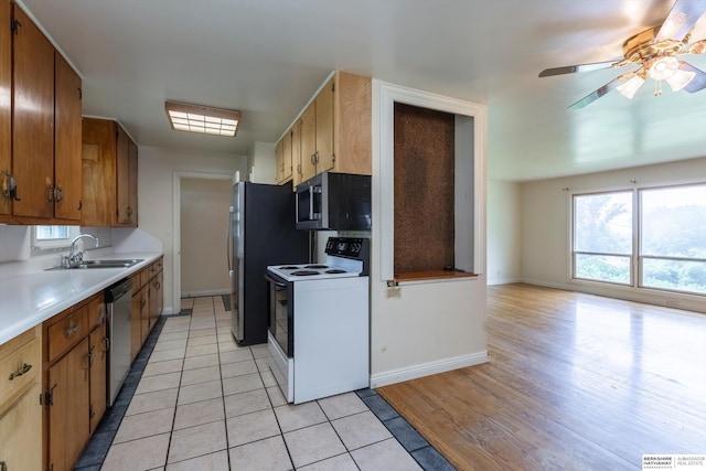 1805 Collins Dr, Bellevue, NE 68005 - kitchen featuring stainless steel appliances, light countertops, light tile patterned flooring, ceiling fan, and brown cabinetry