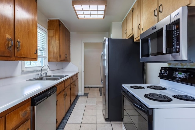 1805 Collins Dr, Bellevue, NE 68005 - kitchen featuring appliances with stainless steel finishes, light countertops, brown cabinetry, and light tile patterned floors