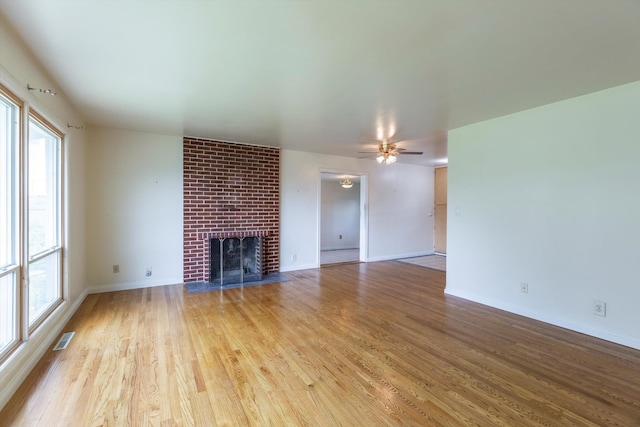 1805 Collins Dr, Bellevue, NE 68005 - unfurnished living room featuring wood finished floors, a brick fireplace, and a ceiling fan