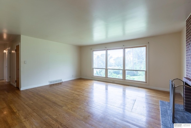 1805 Collins Dr, Bellevue, NE 68005 - unfurnished living room featuring a brick fireplace and wood finished floors