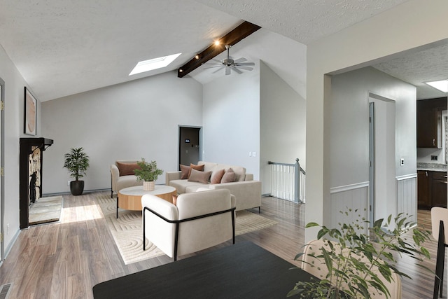 1324 S 162nd St, Omaha, NE 68130 - living room featuring a skylight, light wood-type flooring, a ceiling fan, and a textured ceiling
