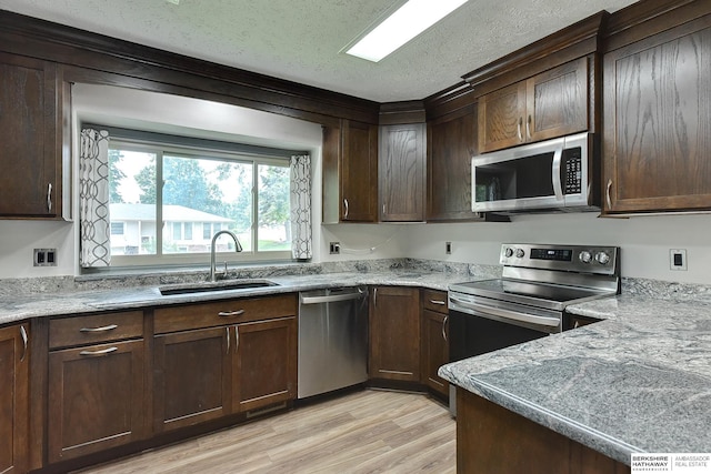 1324 S 162nd St, Omaha, NE 68130 - kitchen featuring appliances with stainless steel finishes, light wood finished floors, dark brown cabinetry, a textured ceiling, and light stone counters