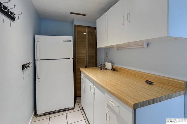 1324 S 162nd St, Omaha, NE 68130 - kitchen featuring freestanding refrigerator, light tile patterned floors, white cabinets, and light countertops