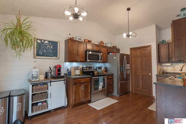 85 Vince Dr, Bennet, NE 68317 - kitchen with appliances with stainless steel finishes, a chandelier, dark countertops, vaulted ceiling, and dark wood-type flooring