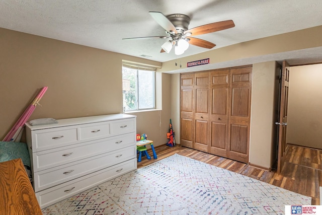 85 Vince Dr, Bennet, NE 68317 - bedroom with light wood-type flooring, a textured ceiling, a closet, and ceiling fan
