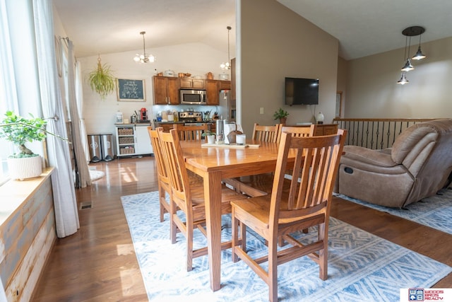 85 Vince Dr, Bennet, NE 68317 - dining room with vaulted ceiling, a chandelier, and wood finished floors
