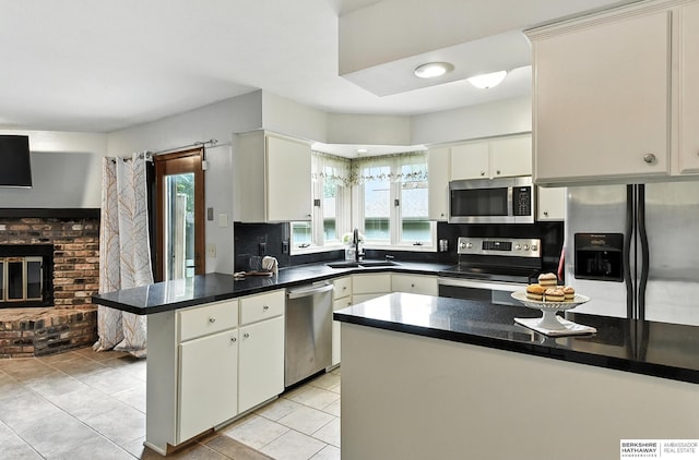 2108 S 62nd St, Omaha, NE 68106 - kitchen featuring appliances with stainless steel finishes, a peninsula, plenty of natural light, and light tile patterned floors