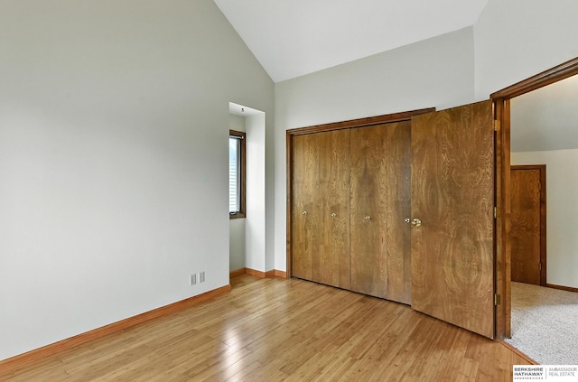 2108 S 62nd St, Omaha, NE 68106 - unfurnished bedroom with a closet, light wood-style floors, and high vaulted ceiling