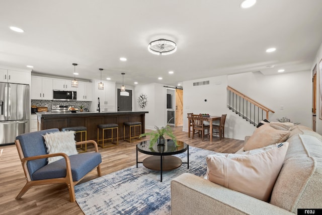 316 N 13th St, Tekamah, NE 68061 - living room featuring stairs, a barn door, light wood-style flooring, and recessed lighting