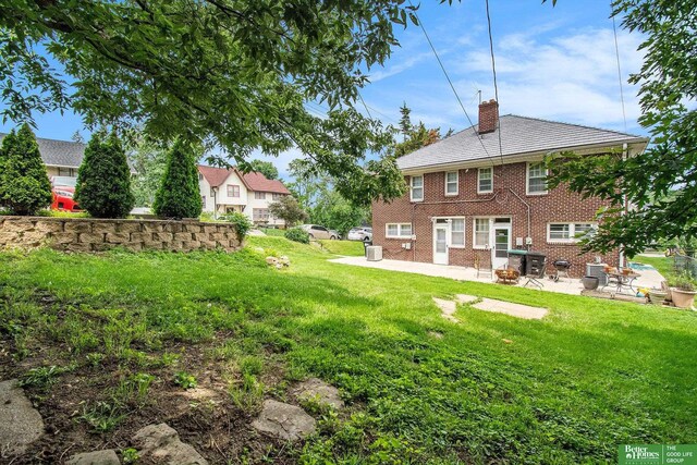 1100/1102 S 35th Ave, Omaha, NE 68105 - back of property with a chimney, a patio, a yard, and brick siding