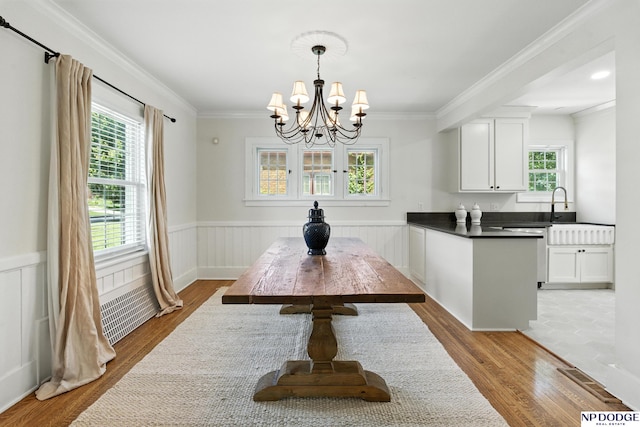 2525 N 55th St, Omaha, NE 68104 - dining space featuring a chandelier, wood finished floors, wainscoting, and ornamental molding
