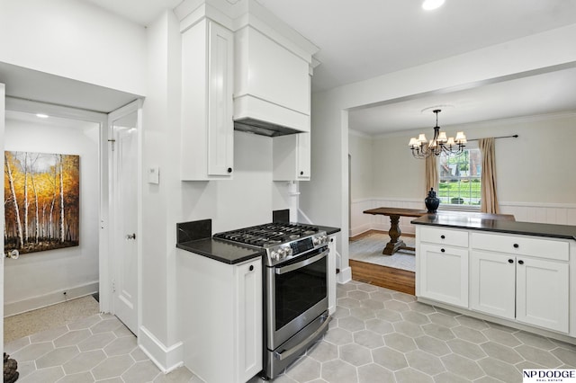 2525 N 55th St, Omaha, NE 68104 - kitchen with stainless steel range with gas cooktop, dark countertops, white cabinetry, light tile patterned flooring, and crown molding