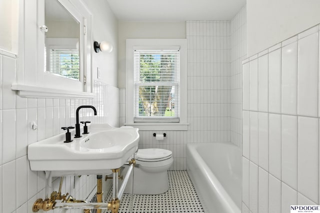 2525 N 55th St, Omaha, NE 68104 - bathroom with tile walls, plenty of natural light, a tub to relax in, and tile patterned floors