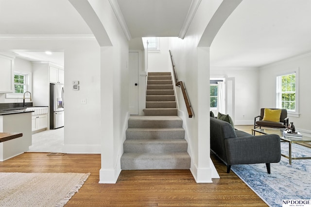 2525 N 55th St, Omaha, NE 68104 - staircase with arched walkways, wood finished floors, and crown molding