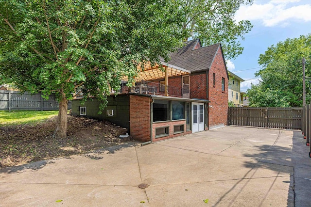 2518 N 56th St, Omaha, NE 68104 - back of property featuring brick siding, a patio, a balcony, and a shingled roof