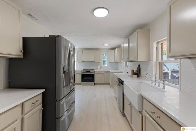 2518 N 56th St, Omaha, NE 68104 - kitchen with stainless steel appliances, light wood-style floors, decorative backsplash, and light countertops