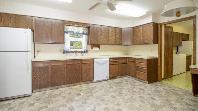 590 Tyler St, Bennet, NE 68317 - kitchen with white appliances, light countertops, separate washer and dryer, ceiling fan, and brown cabinets