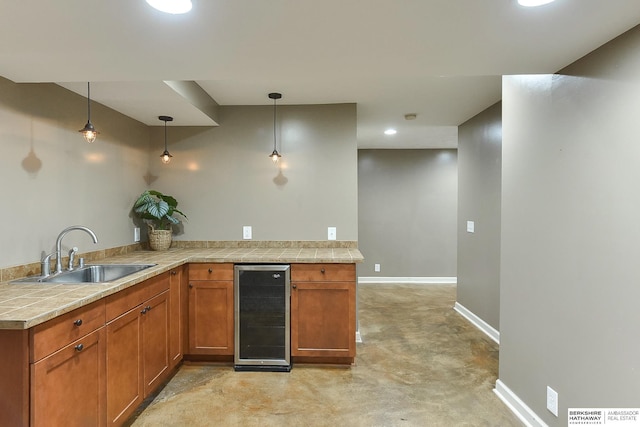 1622 S 179th St, Omaha, NE 68130 - kitchen featuring beverage cooler, finished concrete floors, brown cabinets, decorative light fixtures, and a peninsula