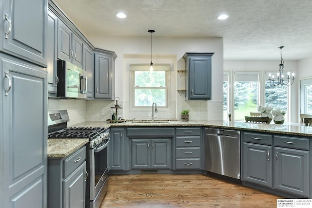 1622 S 179th St, Omaha, NE 68130 - kitchen with stainless steel appliances, gray cabinets, light stone countertops, a chandelier, and recessed lighting
