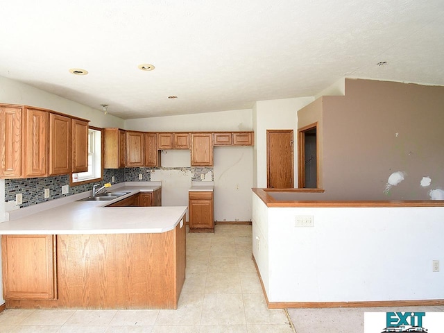 9105 Olive Creek Rd, Hickman, NE 68372 - kitchen with a peninsula, decorative backsplash, brown cabinets, light countertops, and vaulted ceiling