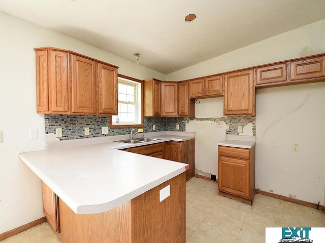 9105 Olive Creek Rd, Hickman, NE 68372 - kitchen with decorative backsplash, a peninsula, brown cabinetry, vaulted ceiling, and light countertops