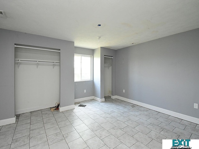 9105 Olive Creek Rd, Hickman, NE 68372 - unfurnished bedroom featuring multiple closets and light tile patterned floors